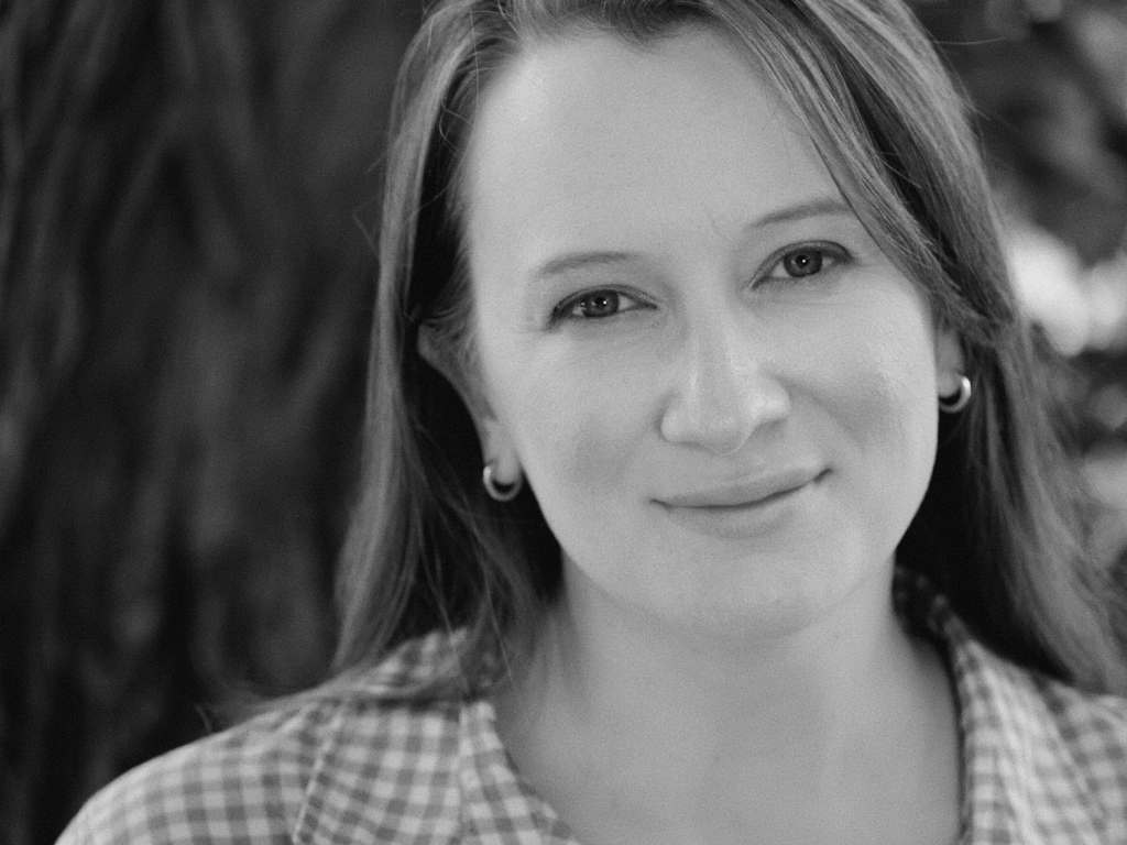 Black and white photo of M. Christine Benner Dixon standing in front of a tree.